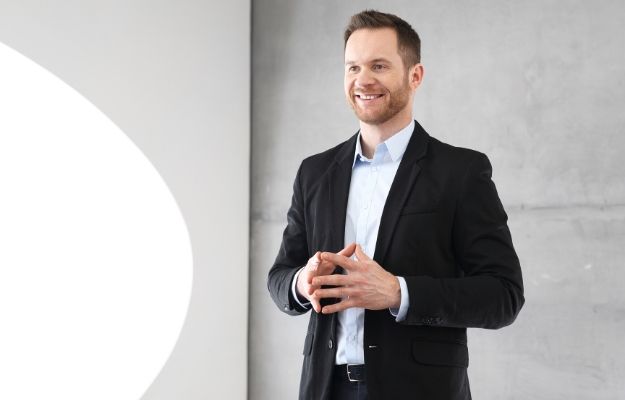 a business man standing giving presentation | Stand up Team Meeting