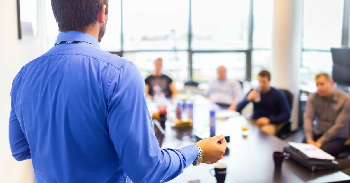 Man standing explaining to the board | How to Pay Your Sales Development Reps | sales development representative salary