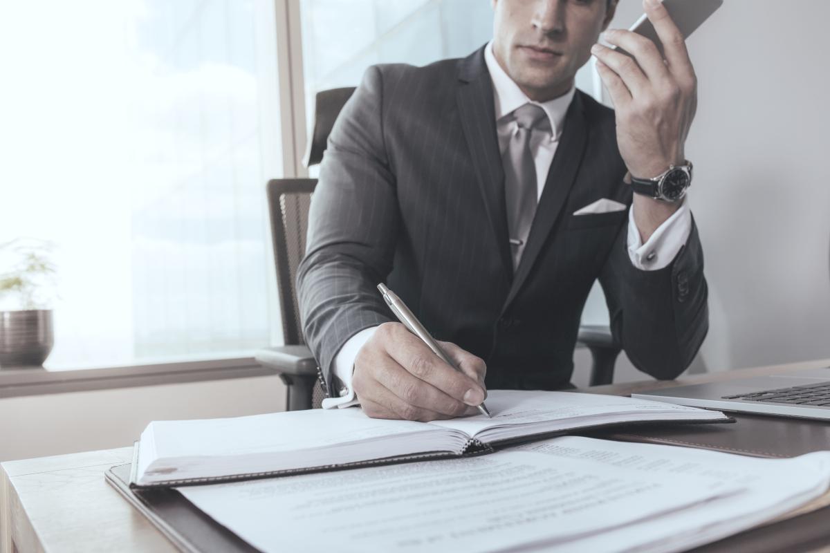 businessman on a phonecall while making notes | Tips To Build A Successful Sales Strategy Plan | sales strategy | how to make a sales plan