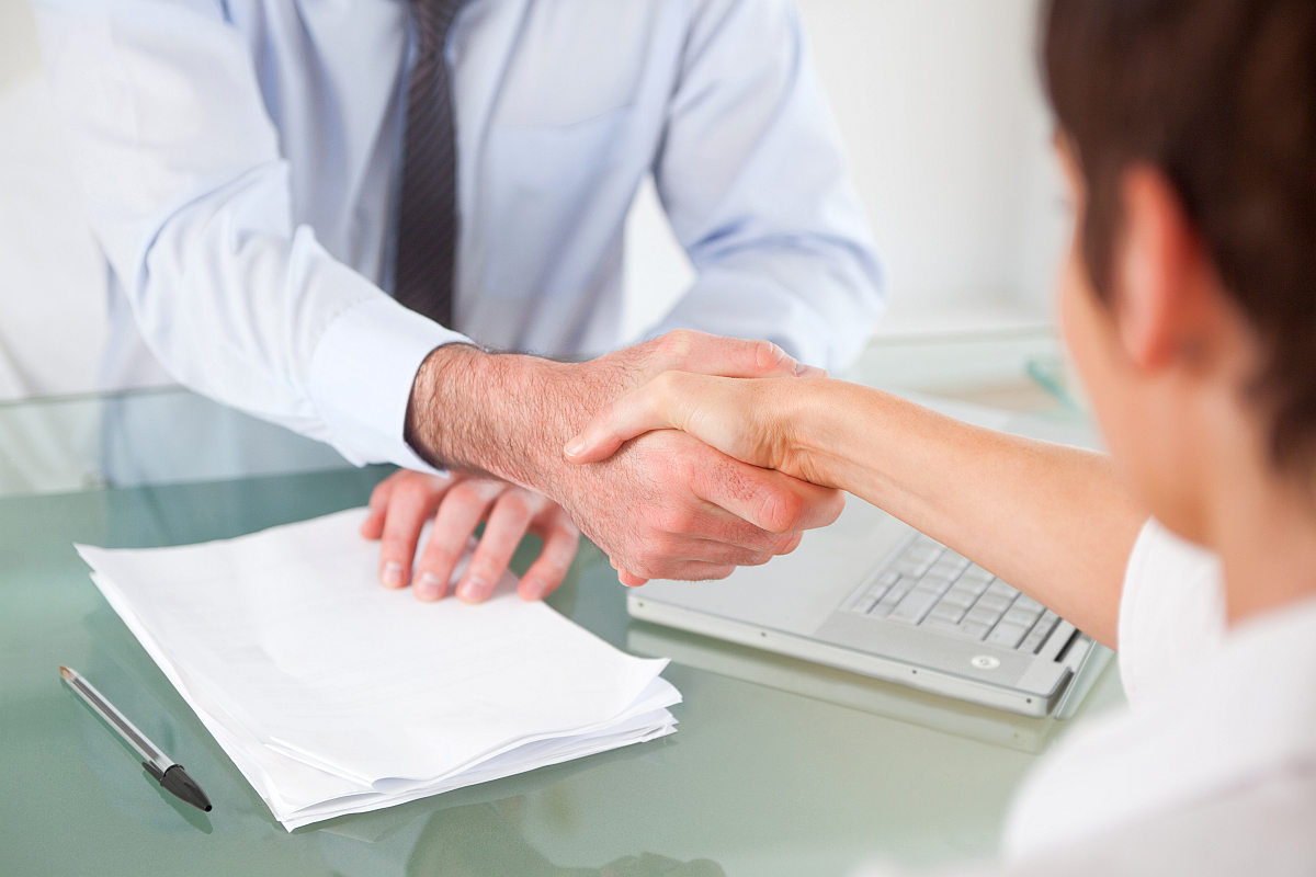 Office workers having hand shake | Onboarding Sales Development - Ready For Sales In Four Steps